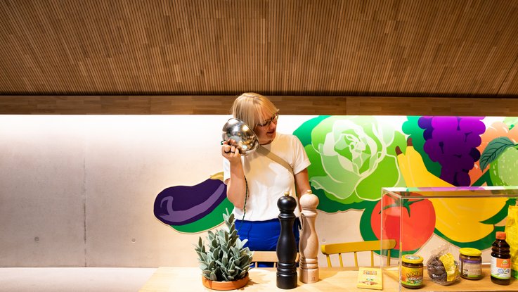 VISUELL Blogbeitrag: Auf Weiterbildung in der Rapunzelwelt. Wir lernen nachhaltige Anbauweisen kennenlernen. VISUELL Blogbeitrag: Weiterbildung in der Rapunzelwelt: Annika von VISUELL steht an einem Exponat des Rapunzel-Ausstellung