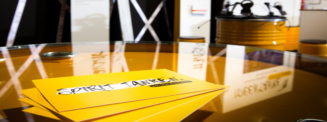 VISUELL Szenografie: Messestand Ideentanke MFG: Detailaufnahme von vier gelben Flyern mit der Aufschrift Spirit tanken