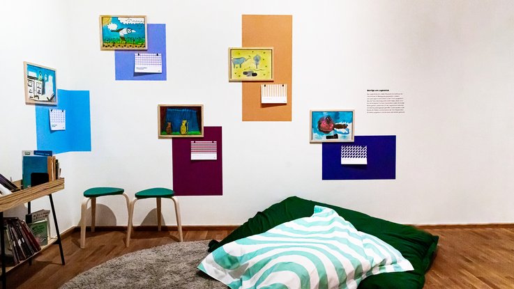 VISUELL Szenografie: Ausstellung „Spurensuche“: Mal- und Leseecke mit Sitzsack und bunter Gestaltung