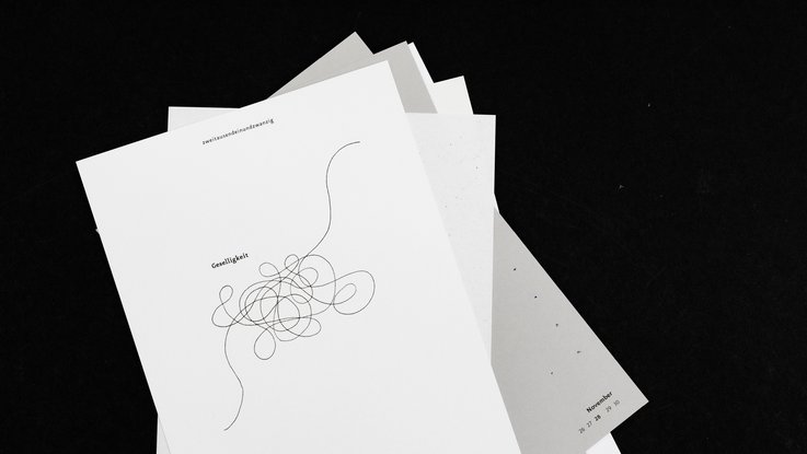 VISUELL Blogbeitrag: VISUELL-Kalender 2021: Mehrere Monatsseiten aufeinander– Aufschrift: Geselligkeit