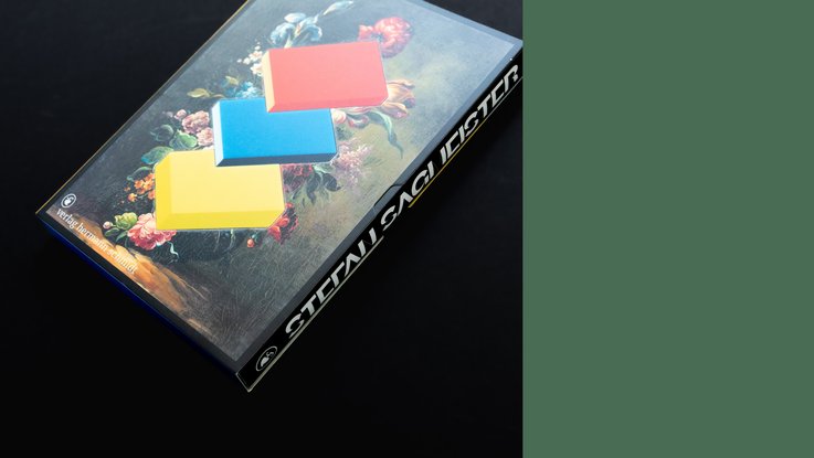 VISUELL Blogbeitrag: Stefan Sagmeister „Heute ist besser": Vorderseite des Schubers des Buchs „Heute ist besser" mit einem Ölgemälde von Blumen und einer überlagerten Infografik, Buchrücken mit dem Autor Stefan Sagmeister in weißer Schrift auf schwarzem Hintergrund