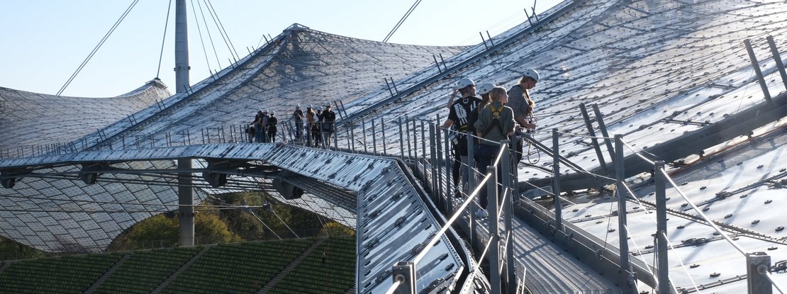 VISUELL Blogbeitrag: Weiterbildung in Innsbruck und München: Das VISUELL Team steht auf dem Dach des Olympiastadions in München