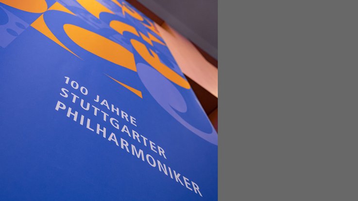 VISUELL Szenografie: Jubiläumsausstellung: Detailansicht eines blauen Banners mit Muster mit der Aufschrift 100 Jahre Stuttgarter Philharmoniker