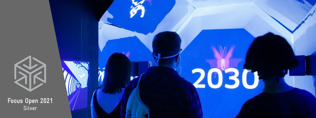 VISUELL Szenografie: Escape-Ausstellung: Besucher stehen im blauen Zeitzug auf dem Weg ins Jahr 2030