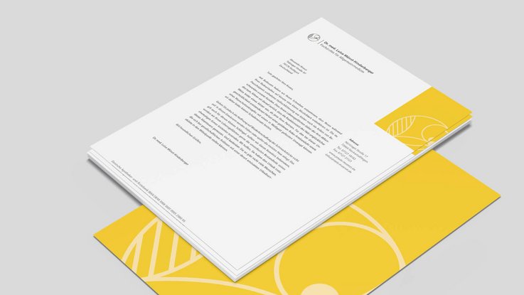 VISUELL Kommunikationsdesign: Corporate Design: Briefbogen mit Vorderseite und gelber Rückseite mit grafischem Element aus dem Logo