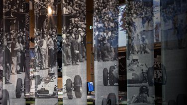 VISUELL Szenografie: Mythos Solitude: Die Stoffbanner, die von der Decke hängen im Detail. Bild eines Solitude-Rennens ist aufgedruckt