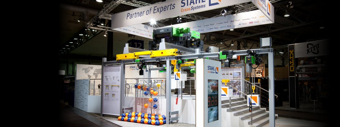 VISUELL Szenografie: Messestand STAHL CraneSystems: Gesamteindruck des offenen, einladenden Messestands, auf dem alle ausgestellten Hebezeuge bedient werden können