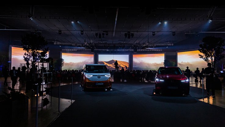 VISUELL Szenografie: BEST CARS 2023: Zwei Autos stehen in der Mitte des Raumes, umgeben von Publikum und Bepflanzung