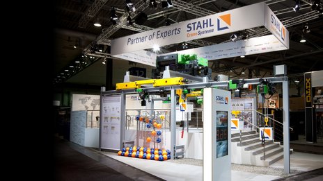 VISUELL Szenografie: Messestand für STAHL CraneSystems auf der CeMAT Hannover VISUELL Szenografie: Messestand STAHL CraneSystems: Gesamteindruck des offenen, einladenden Messestands, auf dem alle ausgestellten Hebezeuge bedient werden können