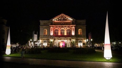 VISUELL Szenografie: Gestaltung und Realisierung des Leitsystems und der Printprodukte für die Nacht des offenen Denkmals in Baden-Baden. VISUELL Szenografie: Nacht des offenen Denkmals: Die Liederhalle in Baden-Baden angeleuchtet bei Nacht mit Leuchtkegeln und Banner ausgestattet