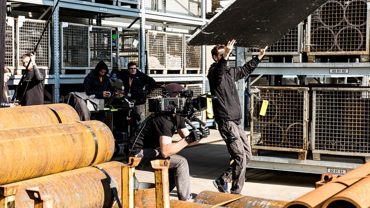 VISUELL Blogbeitrag: Dreharbeiten für STAHL CraneSystems: Personen aus dem Kamera-Team nehmen Einstellungen am Set vor