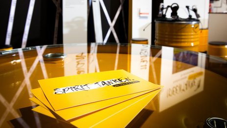 VISUELL Szenografie: Messestand für die MFG auf der Frankfurter Buchmesse VISUELL Szenografie: Messestand Ideentanke MFG: Detailaufnahme von vier gelben Flyern mit der Aufschrift Spirit tanken