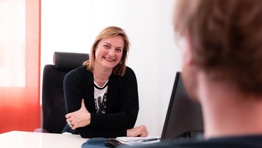 VISUELL Kommunikationsdesign: Corporate Design: Dr. Ines Fleger an ihrem Arbeitsplatz im Gespräch mit einem Patienten.