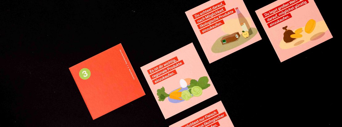 VISUELL Szenografie: Pädagogische Lernkiste: Quadratische Karten in pastellrot mit Illustrationen - Aufschrift: Es ist dir wichtig regionale Produkte zu kaufen; Du legst großen Wert darauf möglichst günstig einzukaufen