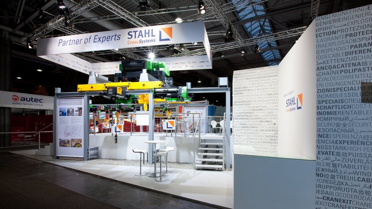 VISUELL Szenografie: Messestand für STAHL CraneSystems auf der CeMAT Hannover VISUELL Szenografie: Messestand STAHL CraneSystems: Gesamteindruck des offenen, einladenden Messestands, auf dem alle ausgestellten Hebezeuge bedient werden können