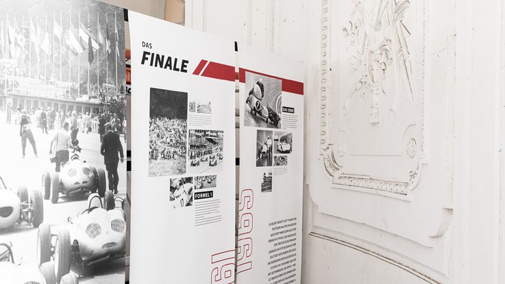 VISUELL Szenografie: Mythos Solitude am Schloss, die Ausstellung bei der Home and Garden VISUELL Szenografie: Solitude Ausstellung: Stoffbanner mit Informationen über "Das Finale" - Bilder des Rennen und Informationstext über 1961 und 1965