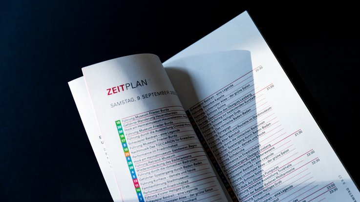VISUELL Szenografie: Gestaltung und Realisierung des Leitsystems und der Printprodukte für die Nacht des offenen Denkmals in Baden-Baden. VISUELL Szenografie: Nacht des offenen Denkmals: Detailaufnahme Innenseite der Wendebroschüre in pink - Aufschrift: Zeitplan