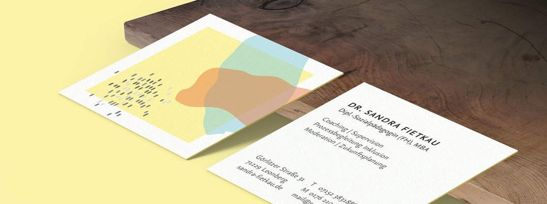 VISUELL Kommunikationsdesign: Visual Identity: quadratische Visitenkarte mit gelbem Rand an der Visitenkarte. Darauf ein gelbes Quadrat und ein rotes, sowie blaues organisches Farbfeld, sowie graue vereinzelte Punkte  