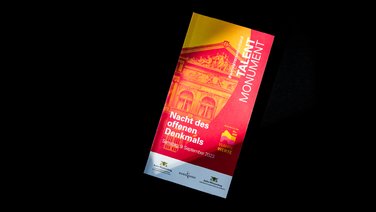 VISUELL Szenografie: Gestaltung und Realisierung des Leitsystems und der Printprodukte für die Nacht des offenen Denkmals in Baden-Baden. VISUELL Szenografie: Nacht des offenen Denkmals: Vorderseite der Wendebroschüre in pink und orange - Aufschrift: Nacht des offenen Denkmals / Talentmonument