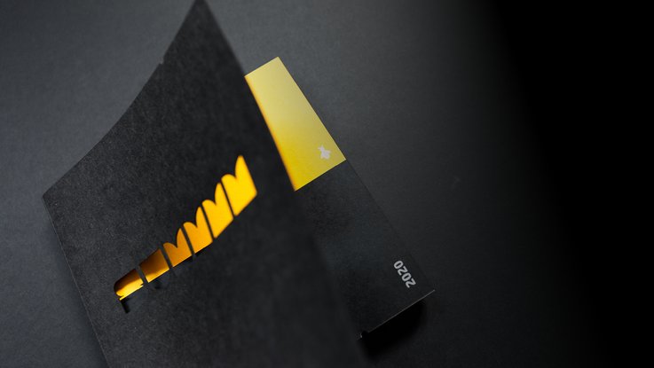 VISUELL Blogbeitrag: VISUELL-Kalender 2020: Vorderansicht Kalenderbuch schwarzes Cover mit Laserung SUMMM mit gelb durchscheinendem Hintergrund