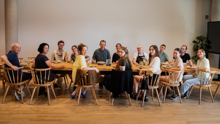 VISUELL Blogbeitrag: Auf Weiterbildung in der Rapunzelwelt. Wir lernen nachhaltige Anbauweisen kennenlernen. VISUELL Blogbeitrag: Weiterbildung in der Rapunzelwelt: Das gesamte VISUELL-Team am Esstisch